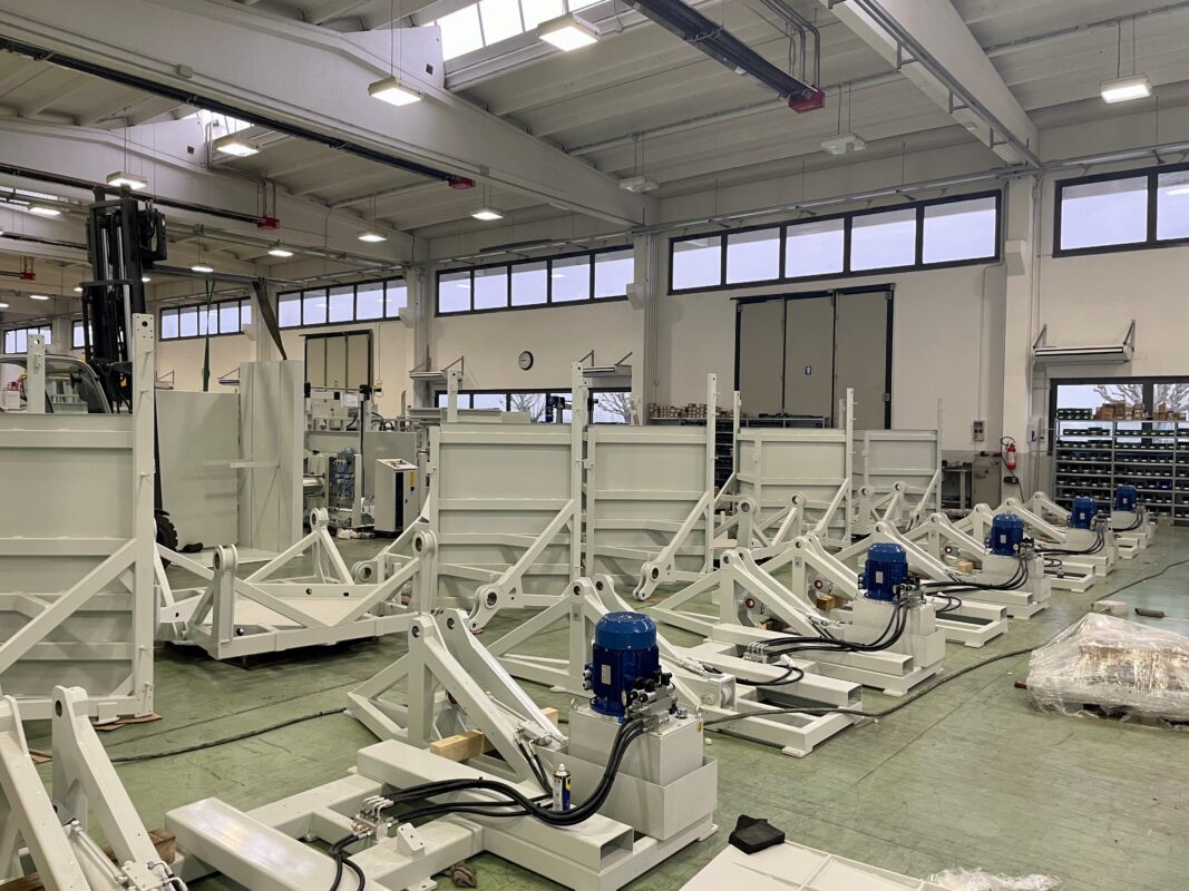 Pallet Inverter Under Production - Image of workers operating the machine in a factory.